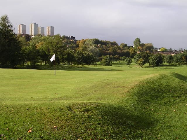 A green at Littlehill, Glasgow's municipal course at Auchinairn, with the city's tower blocks beyond