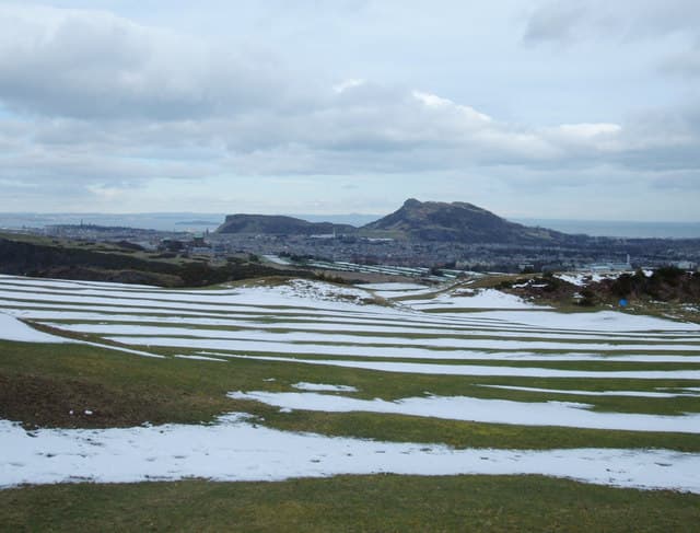 Braid Hills in winter, the fairways under snow and Arthur's Seat across the city