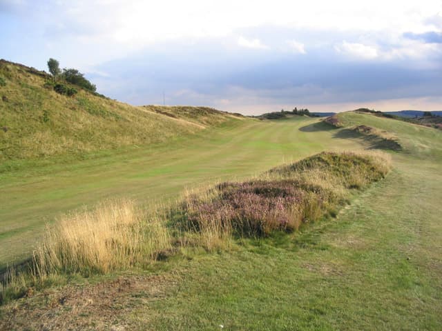 The 8th fairway at Selkirk, heather in bloom on the hill