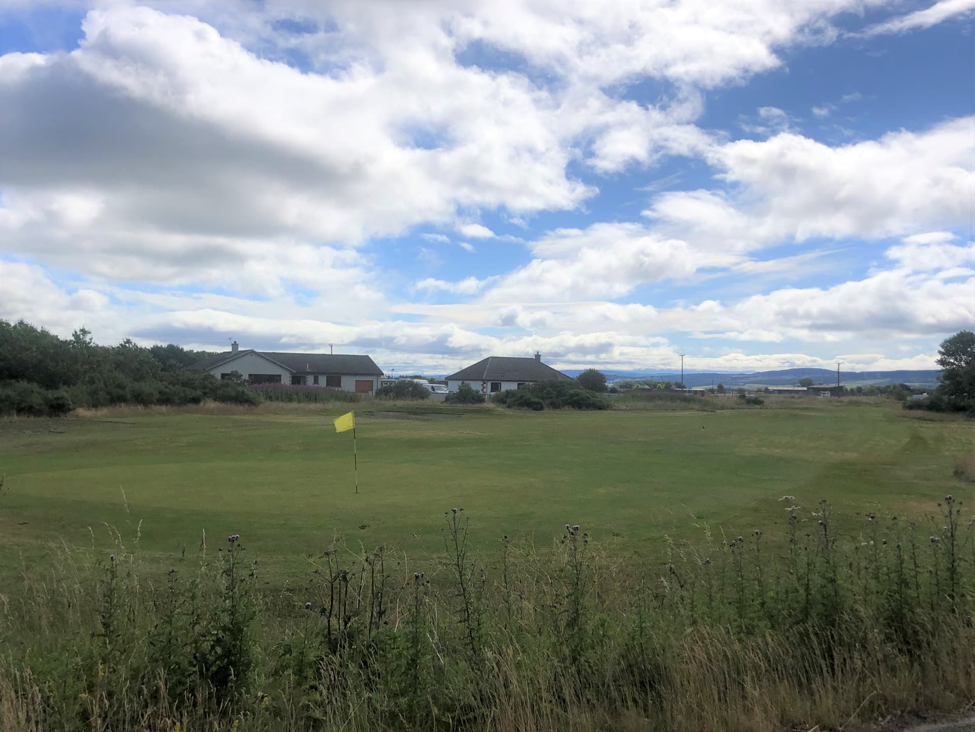 A green and the clubhouse at Muir of Ord, Easter Ross