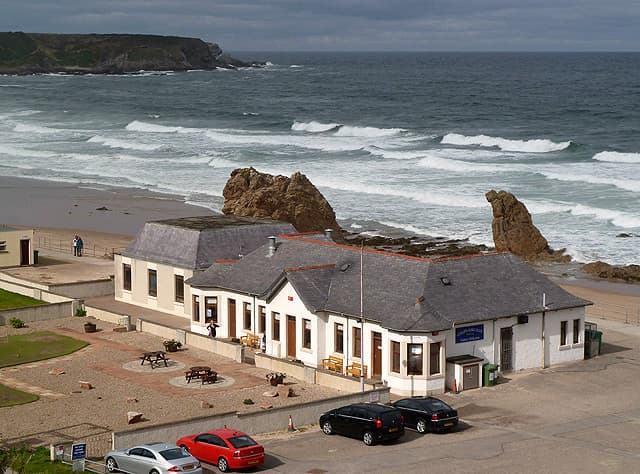 The clubhouse at Cullen, with the sea stacks of the Three Kings on the links below